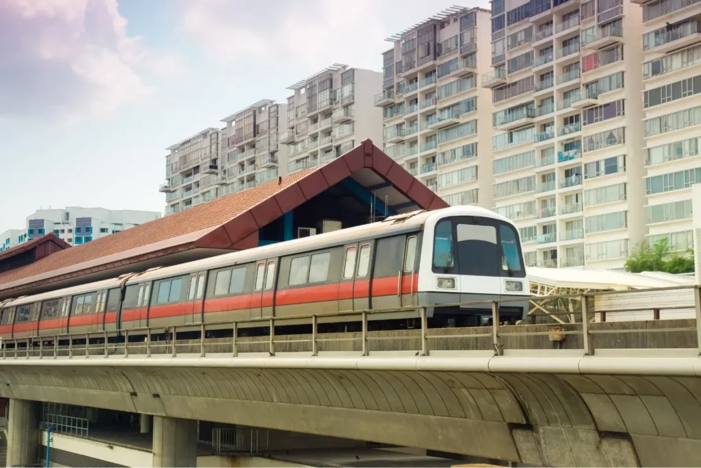 MRT-Zug in Singapur mit modernen Wohnkomplexen im Hintergrund