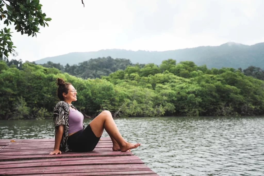 Clara sitzt an einer Bucht in Koh Chang, umgeben von grünen Wäldern – ideal für Erholung im Thailand Urlaub.