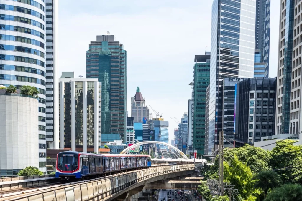 Skytrain in Bangkok, der sich durch die Skyline bewegt, eine praktische Fortbewegungsmöglichkeit für Thailand Backpacking.