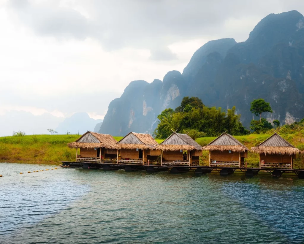 Wasserbungalows im Khao Sok Nationalpark mit Kalksteinfelsen im Hintergrund, ideal für einen einzigartigen Thailand Urlaub.