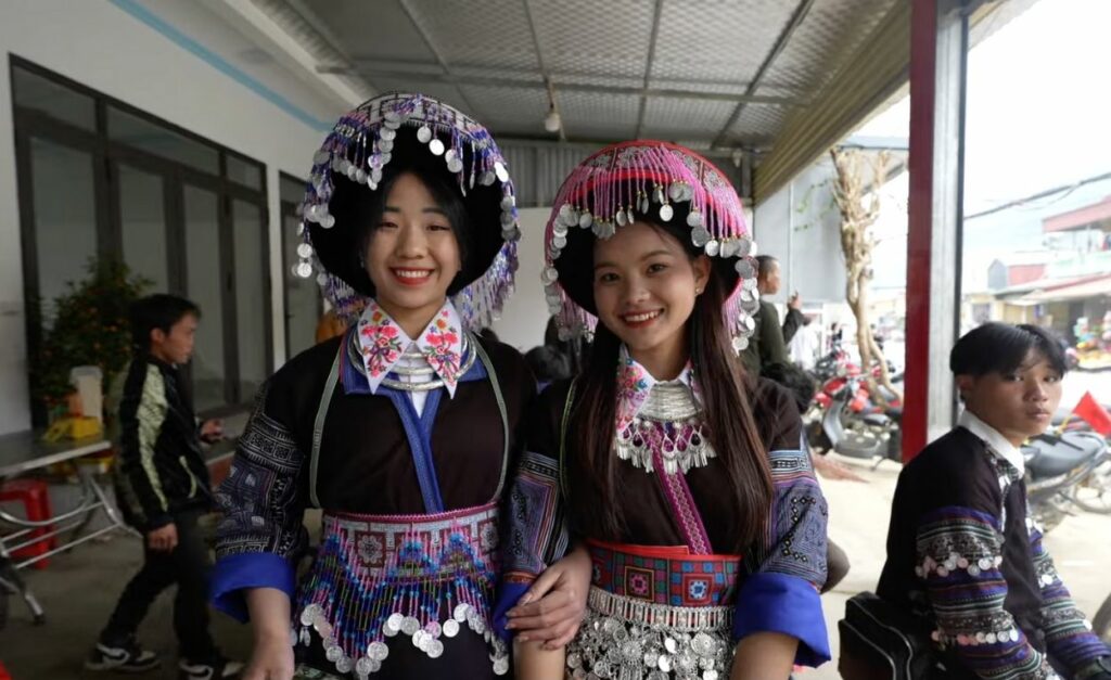Zwei traditionell gekleidete Vietnamesen posieren in Stammeskleidung, ein authentisches Highlight auf der Vietnam Rundreise.