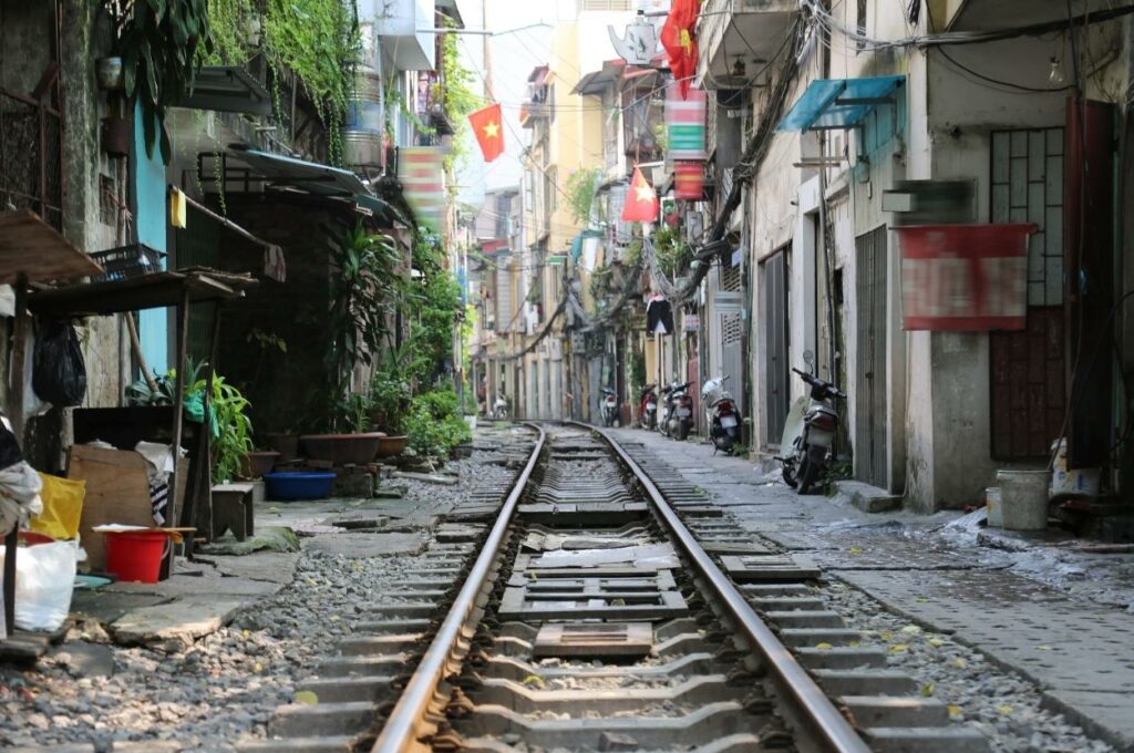 Die berühmte Trainstreet in Hanoi mit vielen alten Gebäuden und einigen Fahnen als ein absolutes Highlight auf der Vietnam Reise.