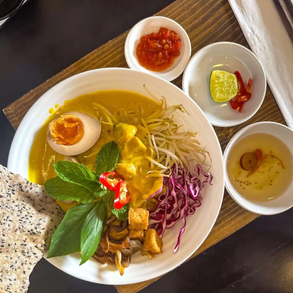 Eine Schüssel Curry mit Nudeln, Kräutern und Limette bietet einen Vorgeschmack auf die kulinarischen Highlights in Vietnam.