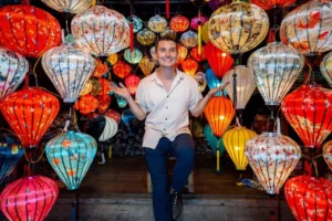 Jonathan strahlt inmitten der leuchtenden Laternen auf dem farbenfrohen Markt von Hoi An auf der Vietnam Reise.