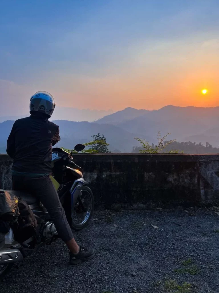 Jonathan auf einem Motorrad mit Sonnenuntergang in den Bergen Vietnams, während der besten Vietnam Reisezeit.