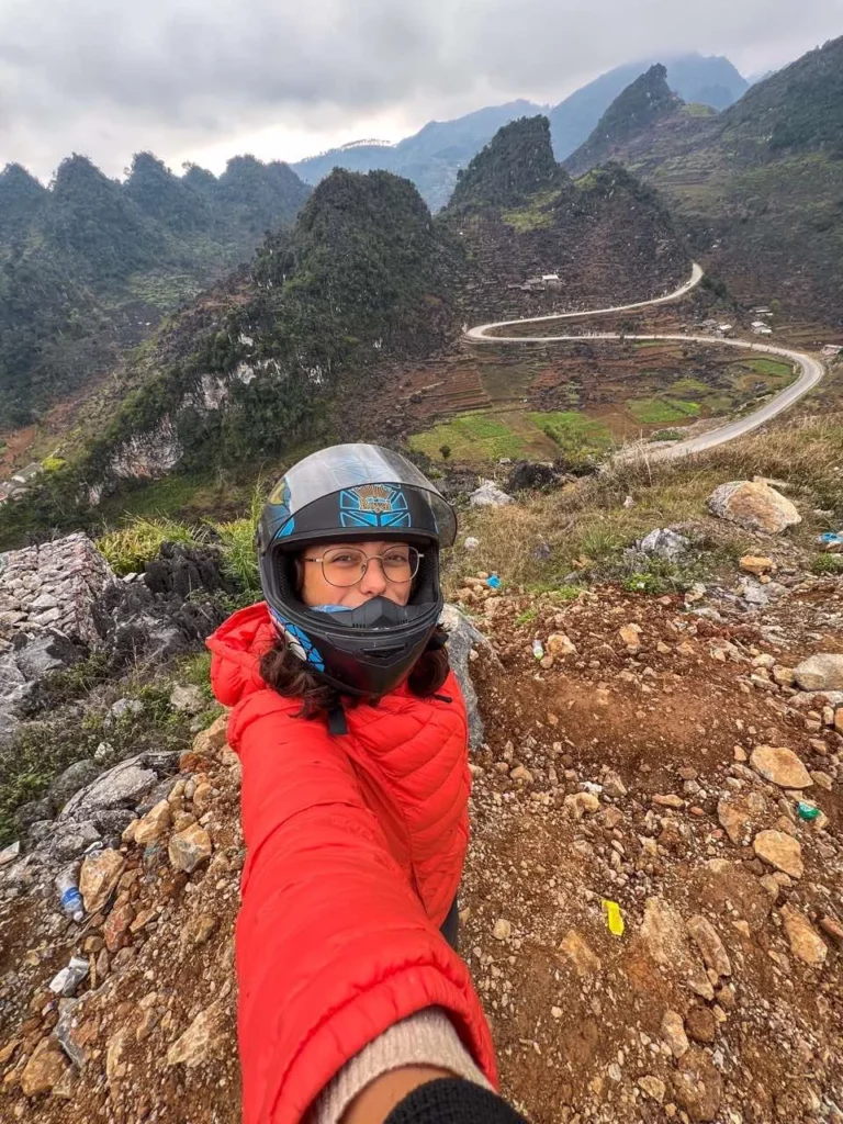 Clara macht ein Selfie auf dem Ha Giang Loop auf kurvenreichen Straße im Hintergrund.
