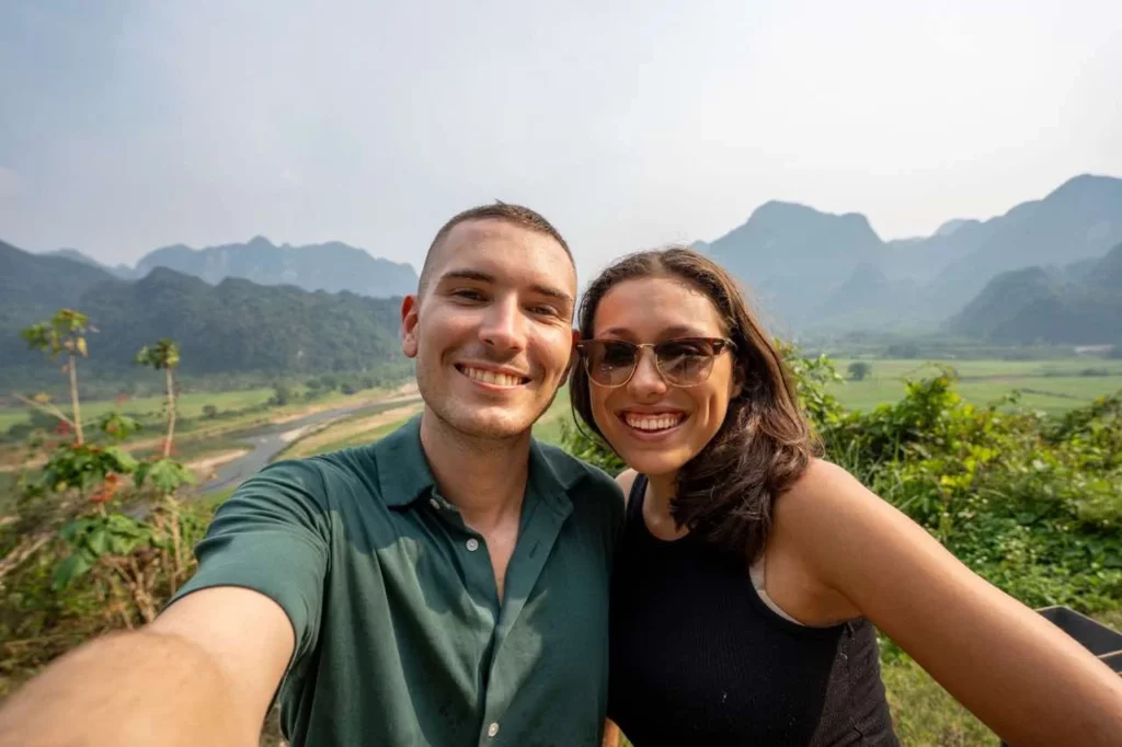 Das Selfie von Clara und Jonathan mit den grünen Berge Vietnams im Hintergrund zur besten Reisezeit des Landes.