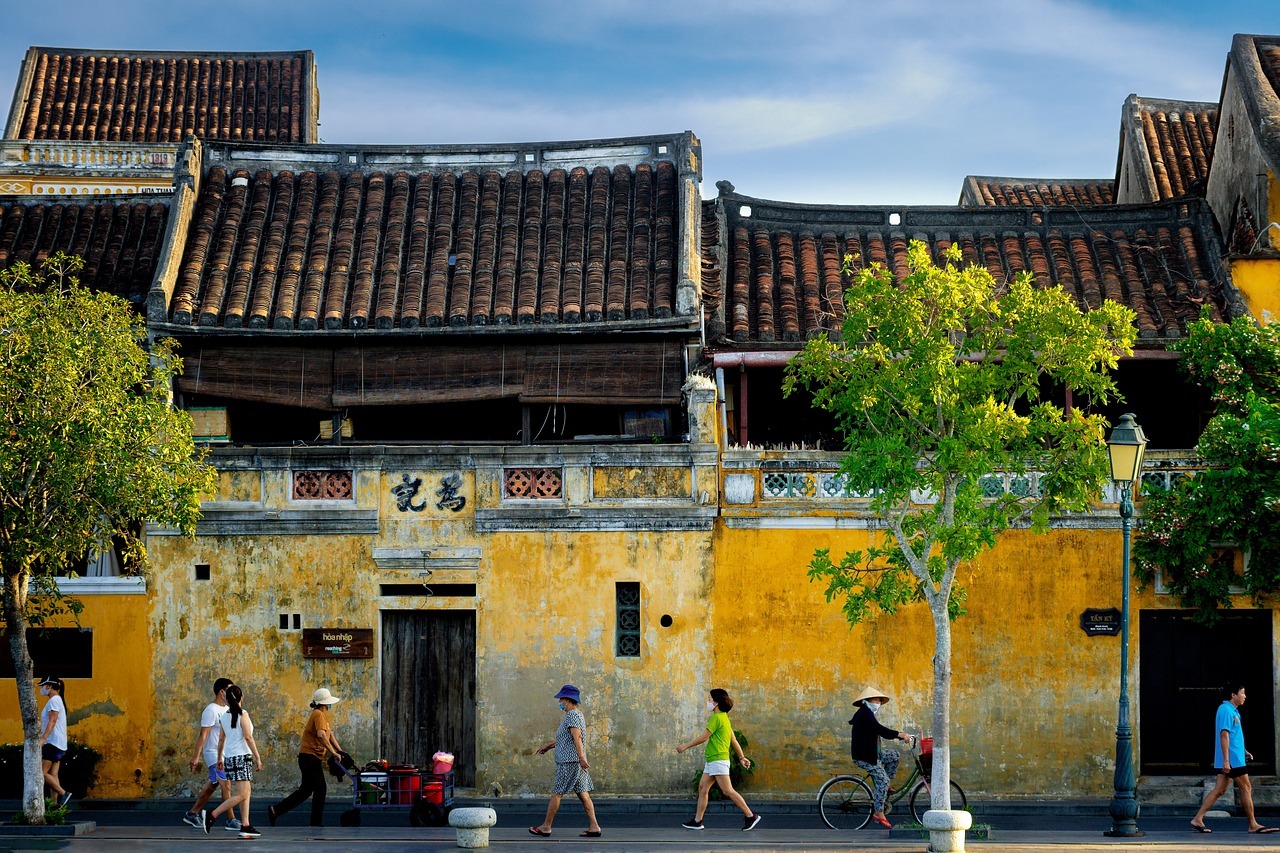 Eine gelbe Wand mit Vietnam Backpacking Reisenden in der bunten Stadt Hoi An.
