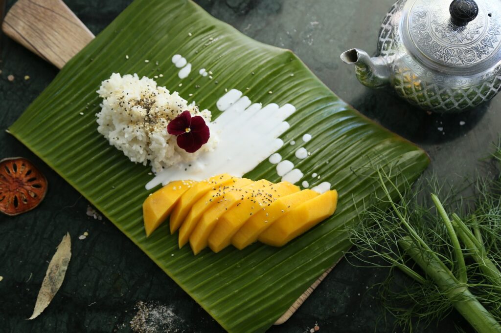 Mango Sticky Rice mit Kokosmilch, ein beliebtes Dessert während eines Thailand Urlaubs.
