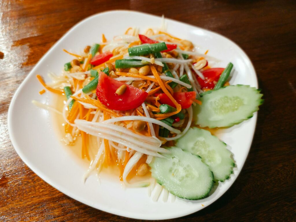 Frischer Papaya Salat (Som Tam) mit Erdnüssen und Gemüse, typisch für Thailand Urlaub