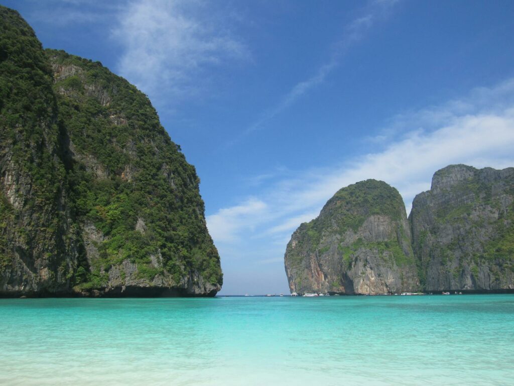 Die ikonische Maya Bay auf Koh Phi Phi mit türkisfarbenem Wasser und dramatischen Felsen, ein Highlight für jeden Thailand Backpacker.