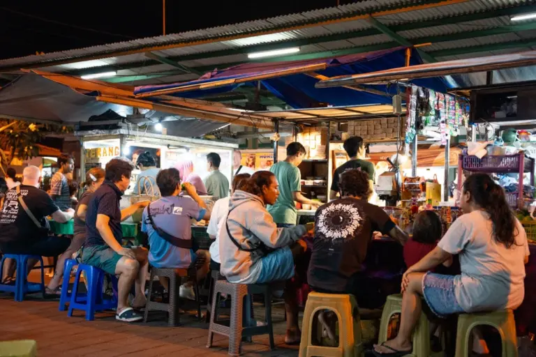 Der Nachtmarkt von Bali erwacht zum Leben, viele Locals sitzen auf dem Markt und essen typisches Streetfood.