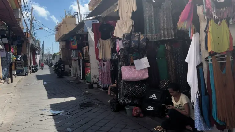 Eine Straße voller Shops und Müll in der Stadt Kuta auf Bali, einem touristischen Spot auf der Bali Rundreise.