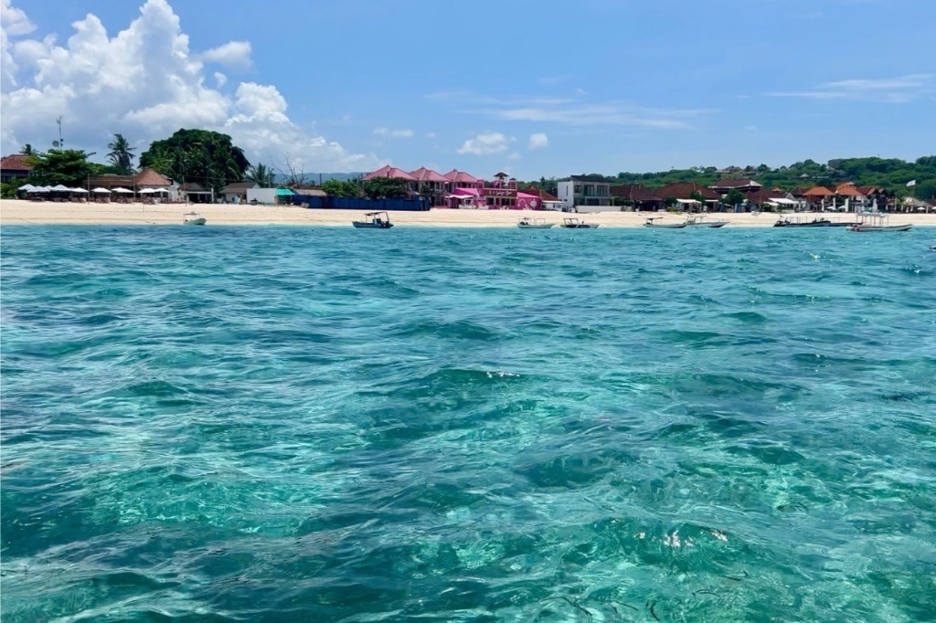 Das türkisfarbene Wasser mit dem schönsten Bali Strand im Hintergrund auf einer Bootstour auf Nusa Lembogan.