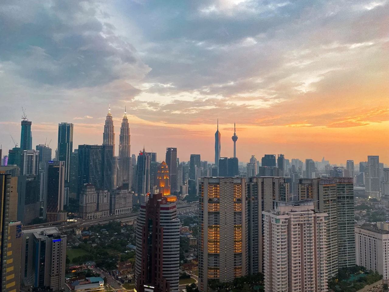 Skyline von Kuala Lumpur im Sonnenuntergang mit Petronas Towers und KL Tower