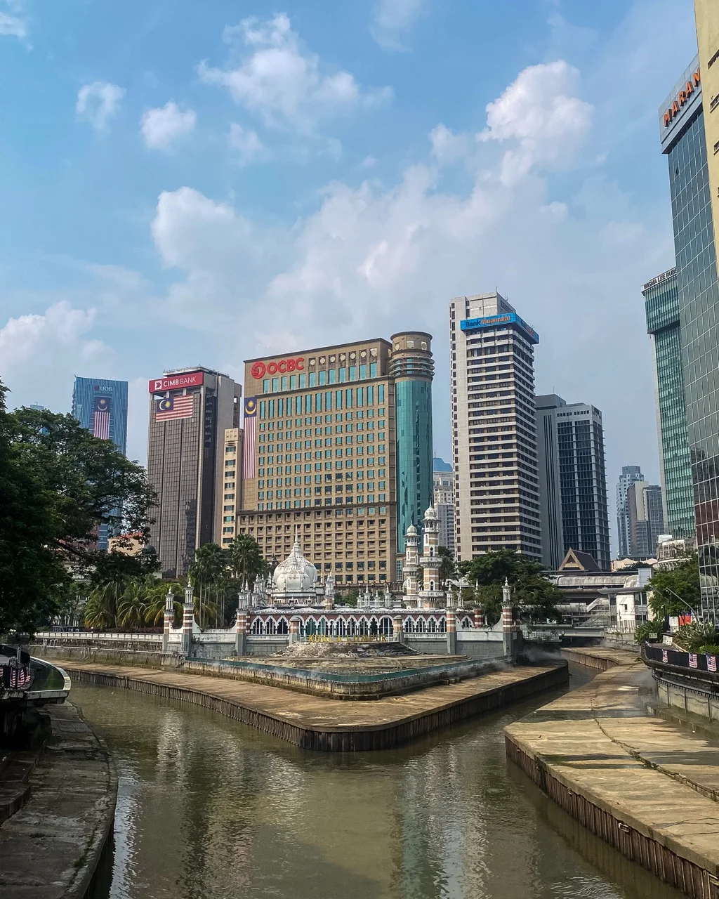 Masjid Jamek am Flussufer vor den Wolkenkratzern von Kuala Lumpur