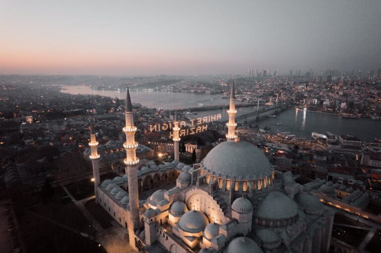 Majestätische Moschee mit hoch aufragenden Minaretten in der Abenddämmerung, mit Blick auf Stadt und Fluss, ideal für Reiseziele 2025.