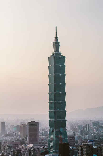 Taipei 101 ragt hoch zwischen den Gebäuden der Stadt hervor, eingehüllt in einen dunstigen Himmel, und ist damit eines der Top-Reiseziele 2025.