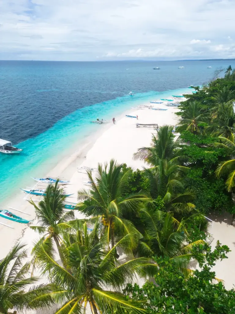 Ein tropischer Strand mit Palmen, weißem Sand und türkisfarbenem Wasser ist ein Muss für Reiseziele 2025.