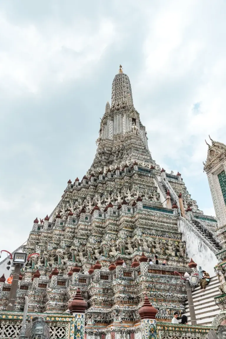 Der goldene Turm eines Tempels glitzert vor stimmungsvollen Wolken; ein ruhiger Ort für Urlaub-2025-Suchende.