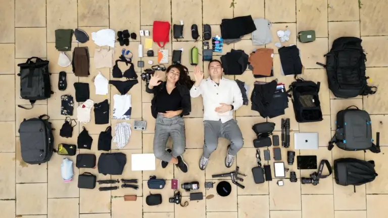 Clara und Jonathan sind umgeben von ihrer Weltreise-Packliste und bereit für ein großes Abenteuer.