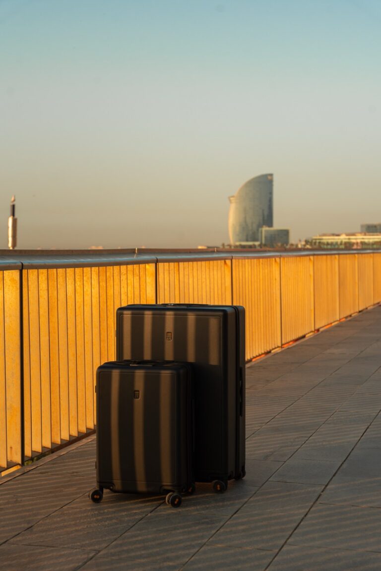 Zwei schwarze Koffer von Level 8 im Test in Barcelona an der Promenade mit Skyline im Hintergrund.