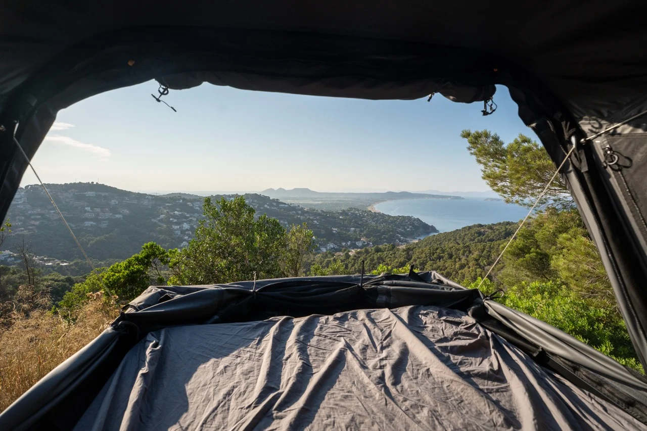 Blick aus dem Roof Space Dachzelt mit Panorama Modus auf die malerischen Hügel der Costa Brava in Spanien.