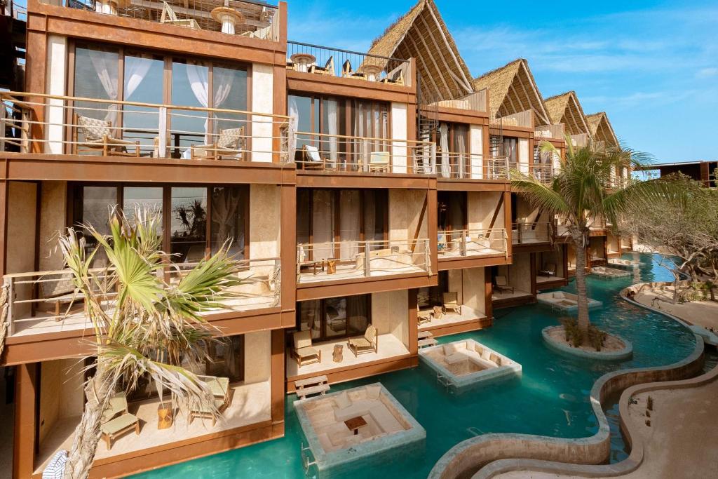 Helles Resort in Yucatan mit privaten Balkonen und einem geschwungenen Pool, ideal für einen unterhaltsamen Mexiko Urlaub.