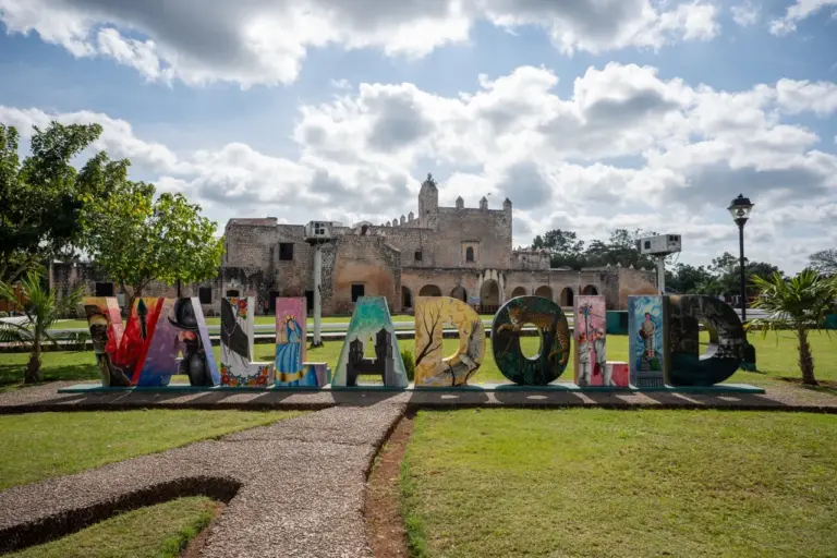 Lebendiges Schild von Valladolid in Yucatan mit bunten Buchstaben vor einem hellen, sonnigen mexikanischen Hintergrund.