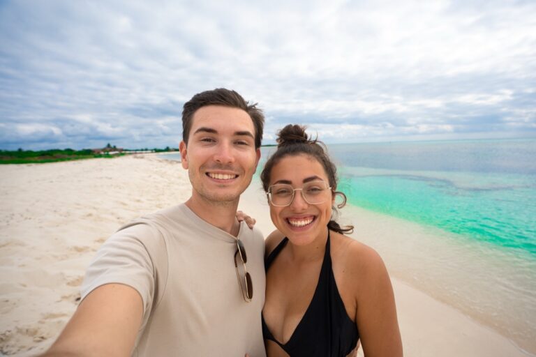 Clara und Jonathan sind mit dem Mexiko Mietwagen an einen Sandstrand in Mexiko mit türkisfarbenem Wasser gefahren.