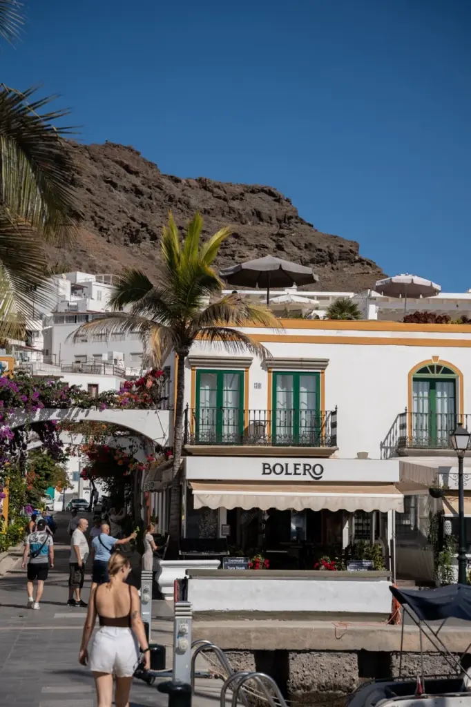Bolero, ein weißes Gebäude auf Gran Canaria, mit Palmen und felsigen Hügeln im Hintergrund.