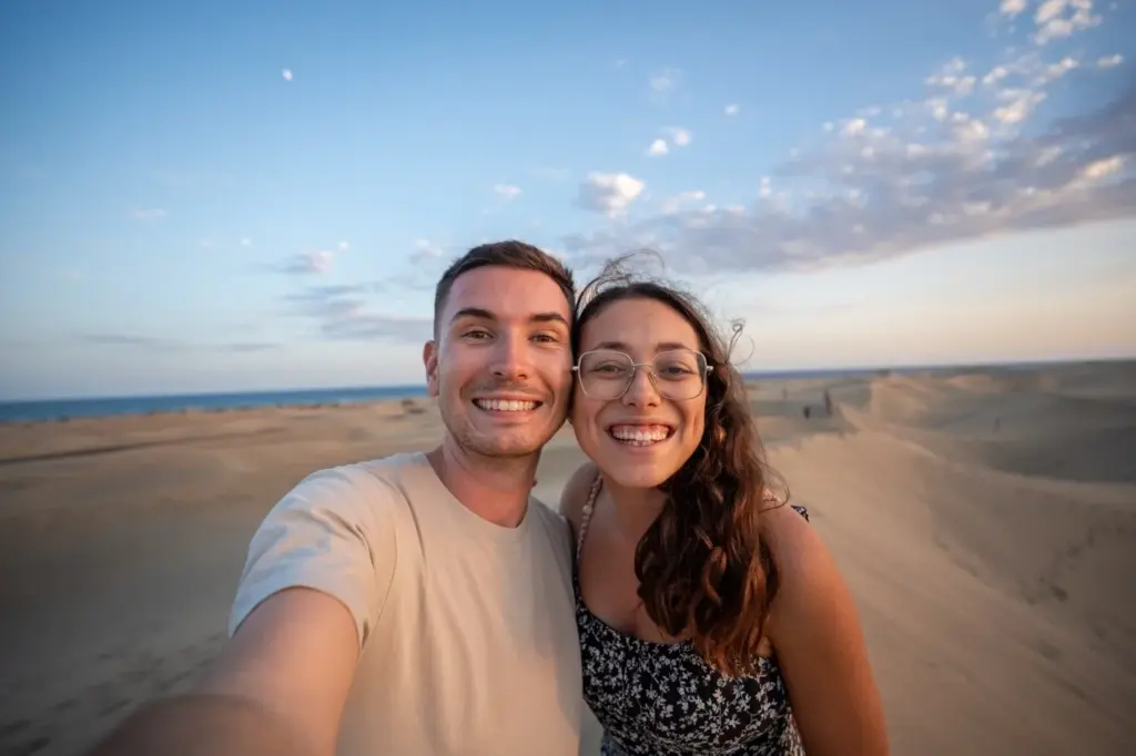 Clara und Jonathan in der Sandwüste Gran Canarias bei strahlend blauem Himmel, perfekt für Reisefotos.