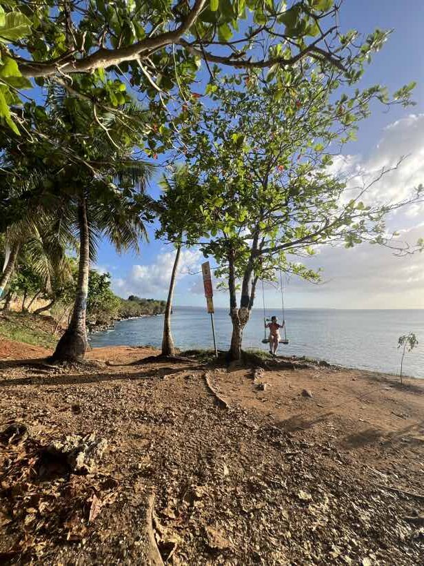 Clara auf einer Schaukel am Strand nahe Crash Boat Beach an der Westküste von Puerto Rico