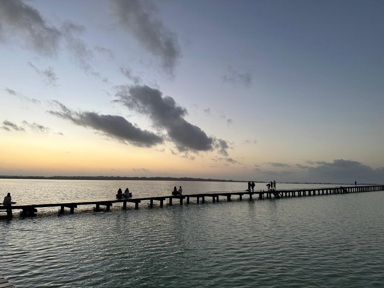 Mexiko beste Reisezeit an der Lagune von Bacalar mit langem Holzsteg in der Abenddämmerung