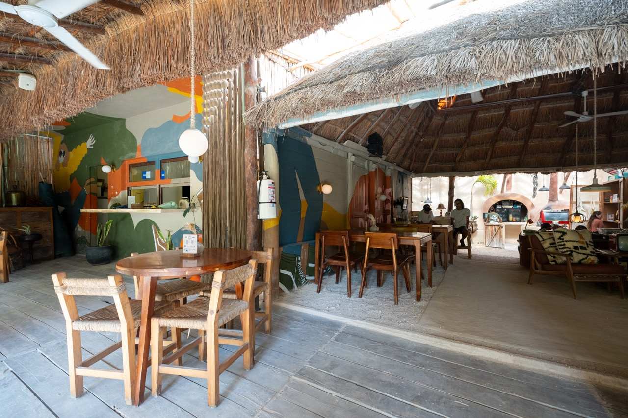 Palapa-Restaurant mit bunten Wandbildern und Holztischen auf Holbox