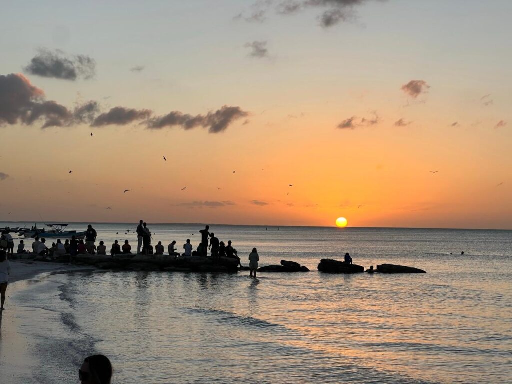 Sonnenuntergang am Meer von Holbox mit Menschen als Silhouetten