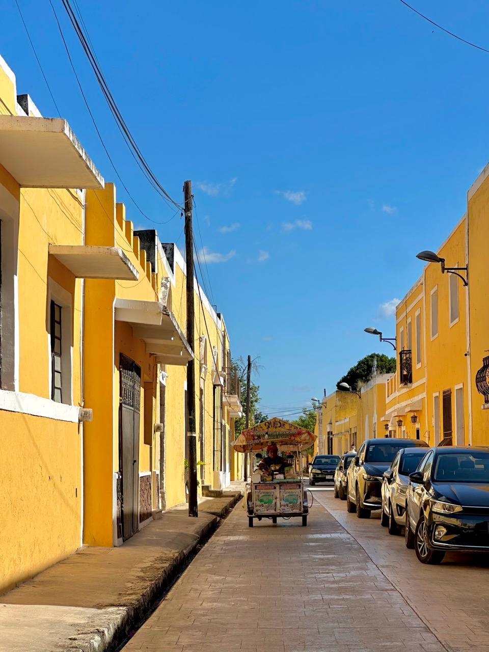 Gelbe Kolonialgasse mit Streetfood-Wagen in Izamal, Yucatan