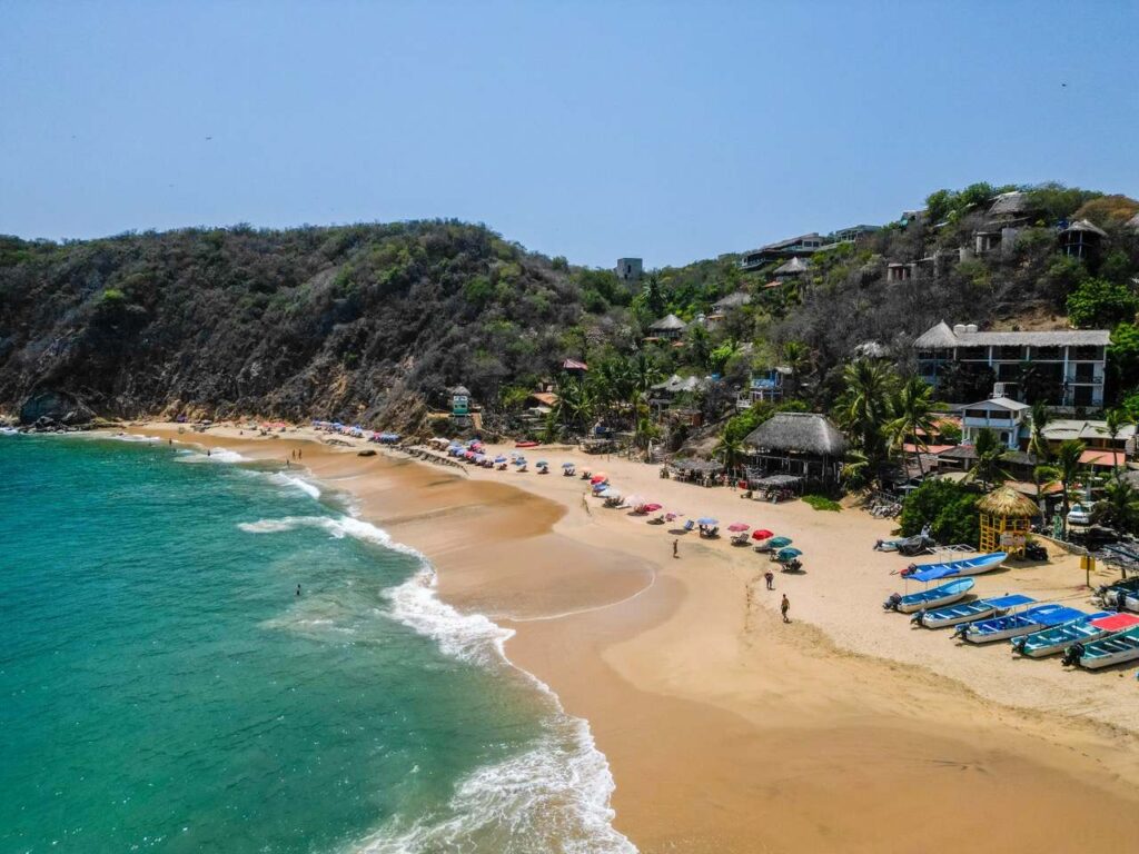 Luftaufnahme von Strand mit Booten und Sonnenschirmen in Mazunte