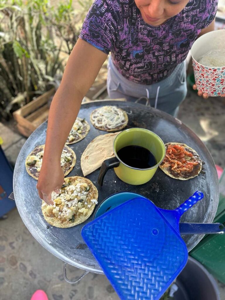 Belegte Memelas auf dem Comal und ein Becher Kaffee an einem Stand in Oaxaca