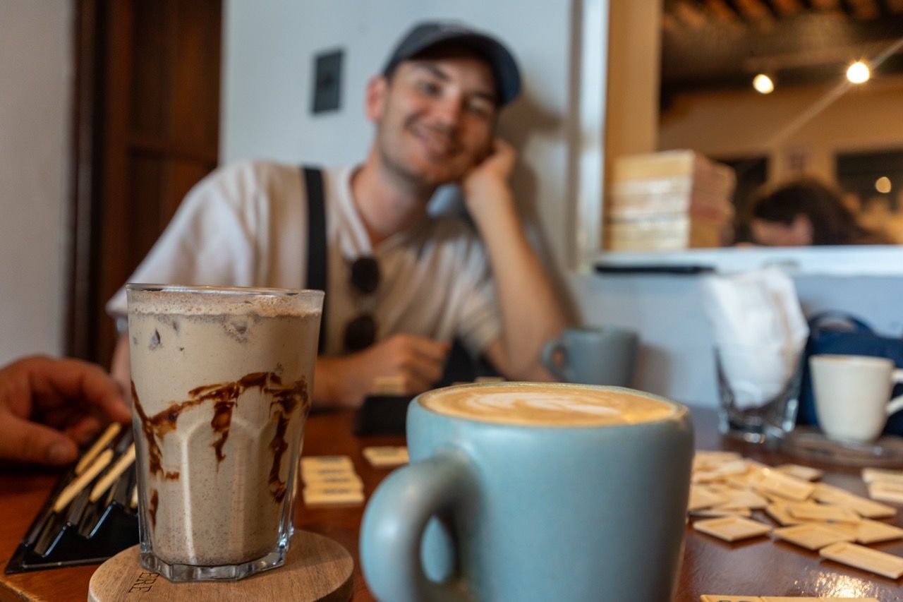 Mann in einem Cafe in Merida mit Latte und Eiskaffee auf dem Tisch
