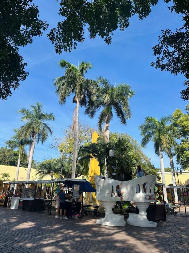Palmen und Marktstaende auf der Plaza von Merida