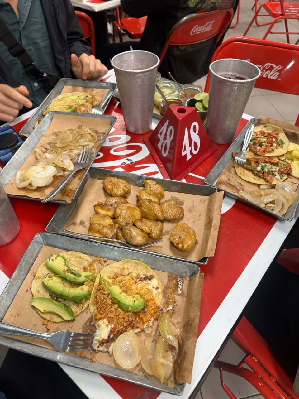 Tacos und Beilagen auf Tabletts in einer Taqueria in Mexico City
