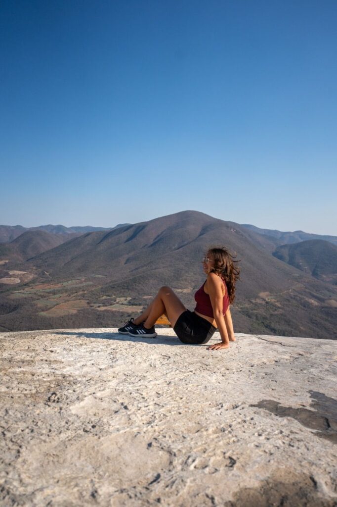 Frau auf der Felsplattform von Hierve el Agua mit Bergpanorama bei Oaxaca