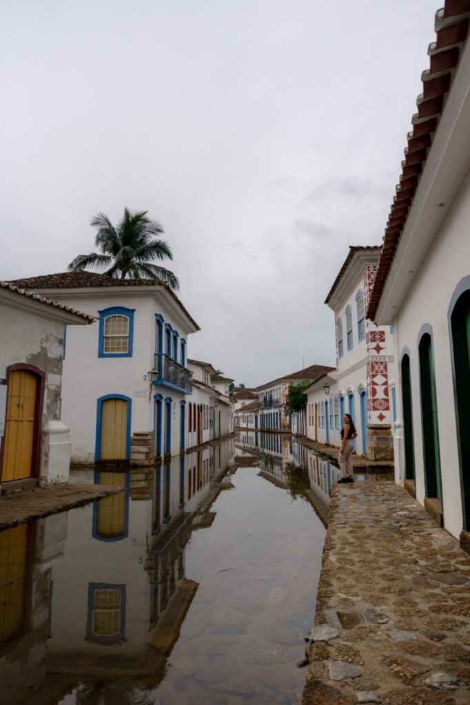 Kopfsteingasse mit weißen Häusern und Palmen in Paraty