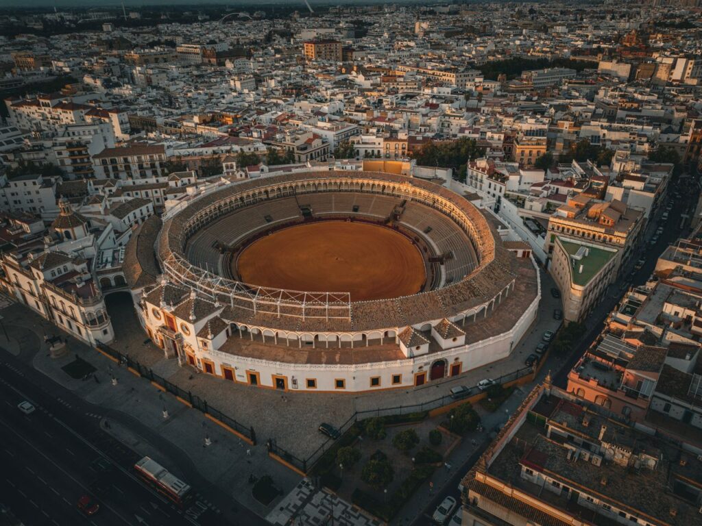 Stunning drone shot of Plaza de Toros de la Maestranza amid Seville's urban landscape.