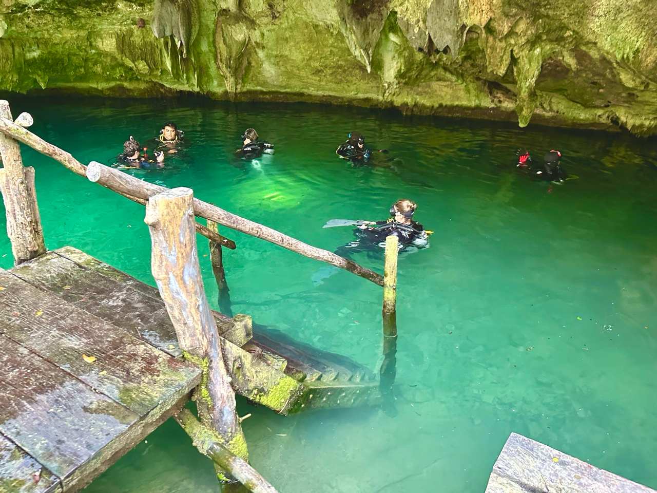 Taucher in einer gruenen Cenote bei Playa del Carmen