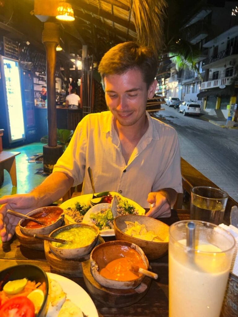 Mann isst abends Tacos in einem Restaurant in Puerto Escondido