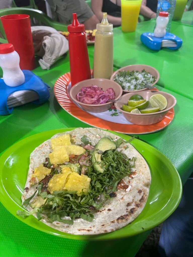 Tacos mit Beilagen auf einem Tisch bei einem Streetfood-Stand in Puerto Escondido