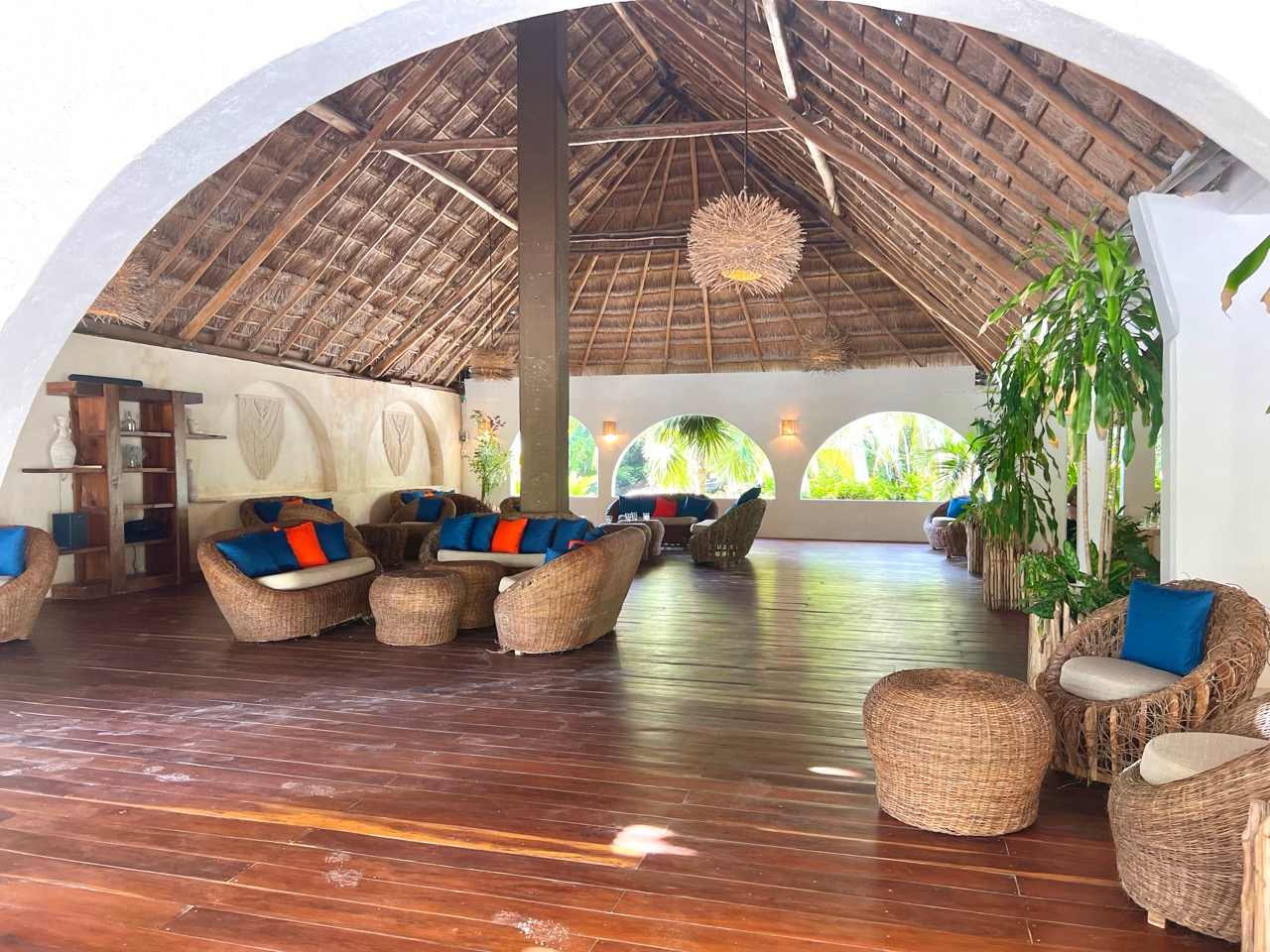 Lounge mit Rattanmoebeln unter Palmdach in einem Hotel in Tulum