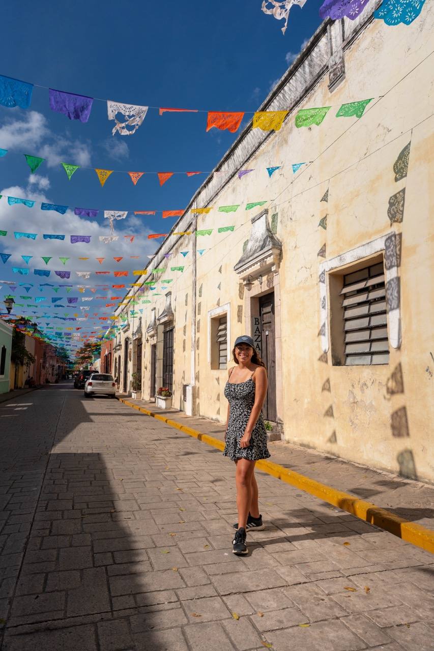 Frau in der Calle de los Frailes mit Papel Picado in Valladolid, Yucatán